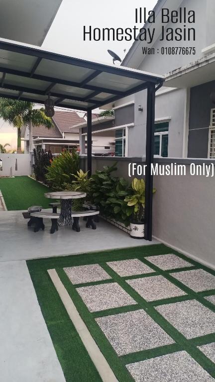 a patio with two benches and a table in front of a house at illa Bella Homestay Jasin in Jasin