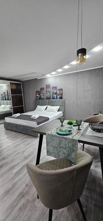 Un dormitorio con una cama, una mesa y una silla. en LUX-Апартаменты New York style на Чехова, en Öskemen