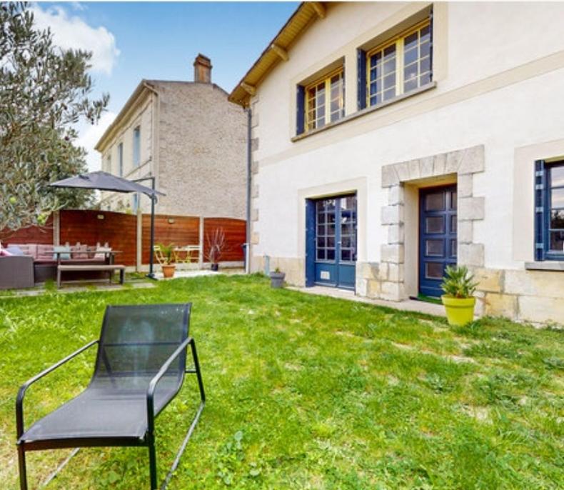 a black chair in the yard of a house at Maison typique royannaise dans un quartier calme in Royan
