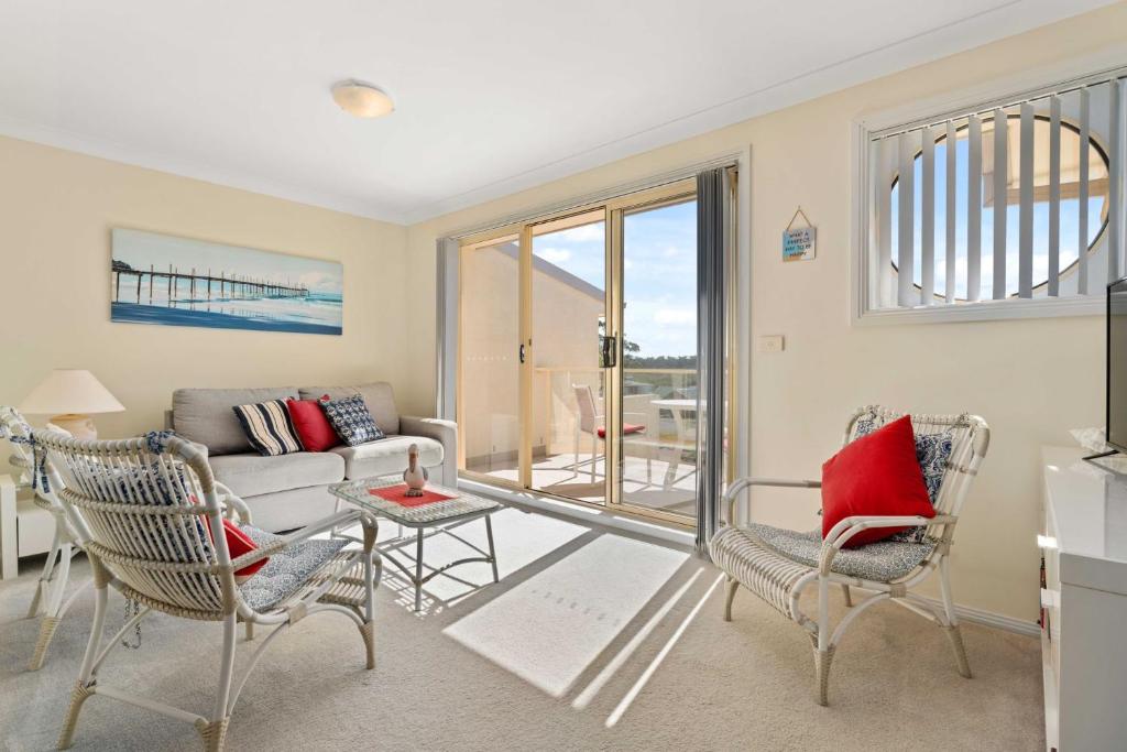 a living room with a couch and chairs at Pier 8 by Experience Jervis Bay in Huskisson