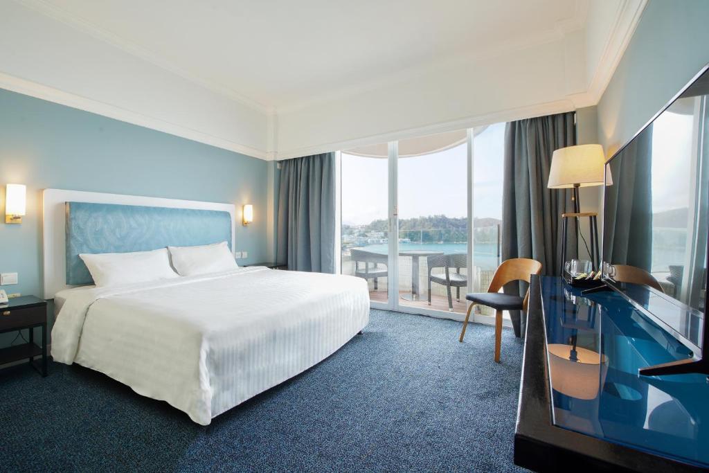 ein Hotelzimmer mit einem Bett und einem Schreibtisch mit Fernseher in der Unterkunft Warwick Hotel Cheung Chau in Hongkong