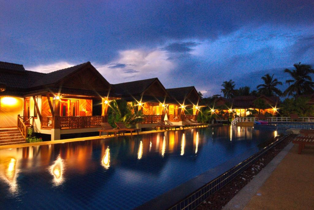 una grande piscina in un resort di notte di Sangsawan Palace Khaolak Resort a Khao Lak