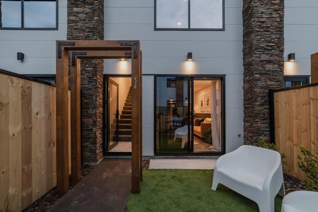 an open door to a patio with a white chair at Luxury Central City Getaway in Christchurch
