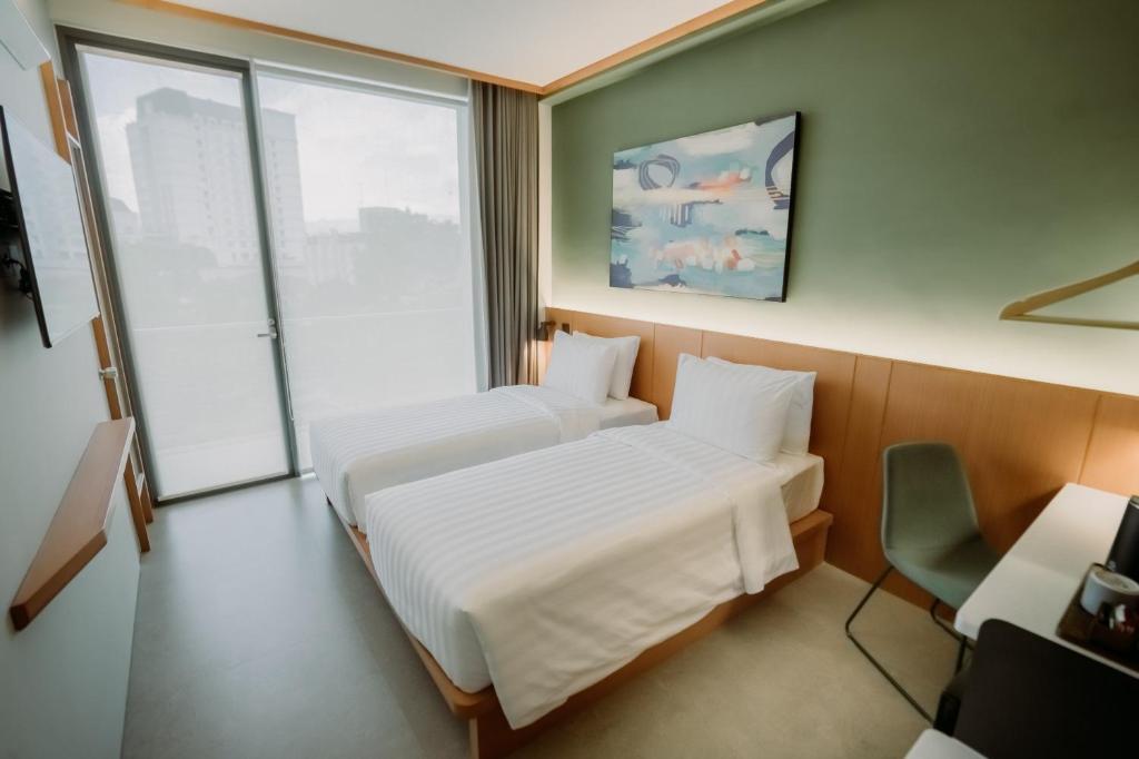 Postel nebo postele na pokoji v ubytování Jiro Hotel