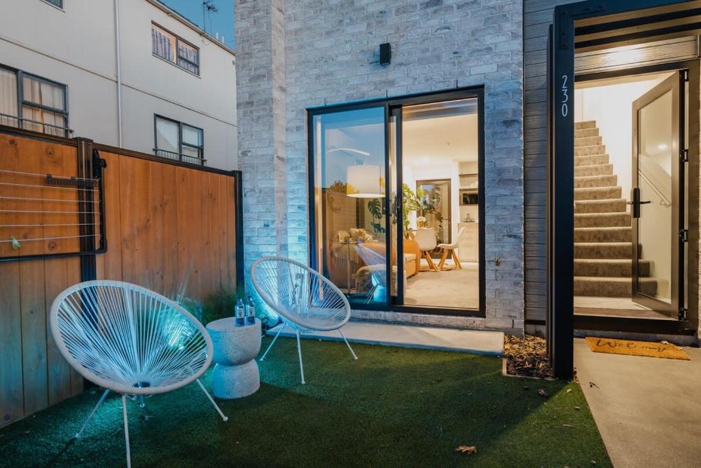 クライストチャーチにあるThe Coolest Townhouse in Christchurchの家の横に座る青い椅子2脚