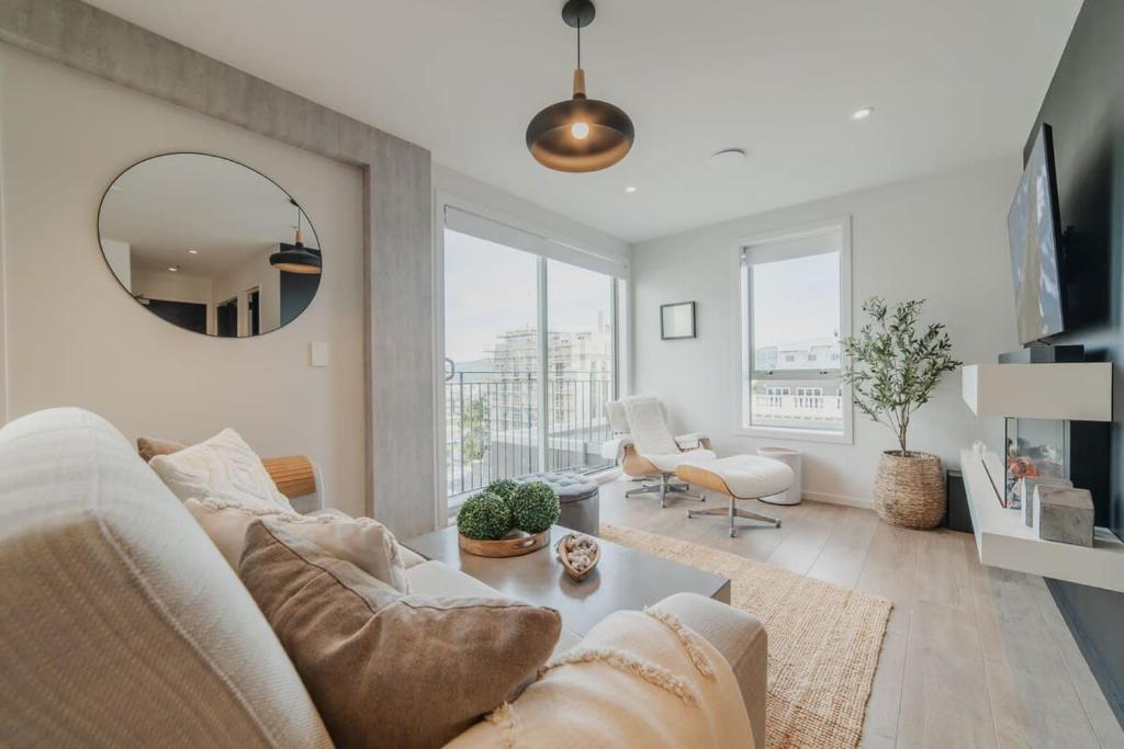 基督城Penthouse Perfection - 2BR Elegance on Worcester St的客厅配有白色沙发和镜子