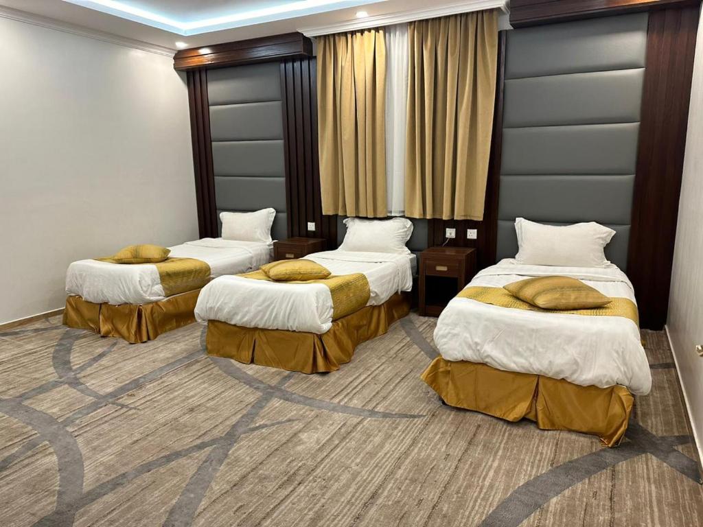 a hotel room with three beds in a room at فندق المغاربي 1 in Al Madinah