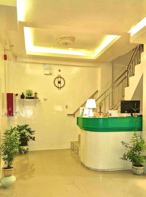 a lobby with a waiting area with potted plants at Drossgold Pension House in Tubigon