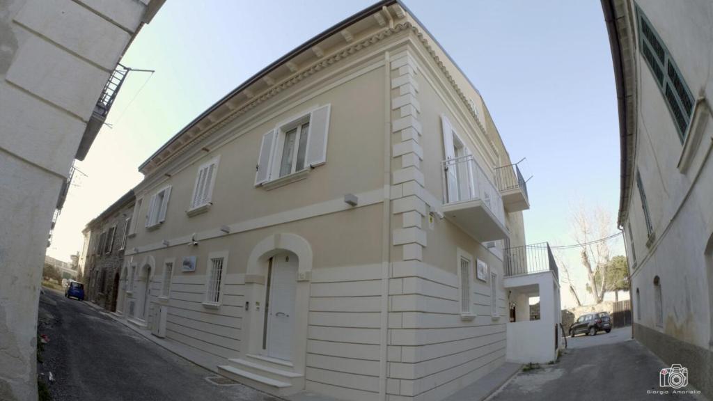 a white building with an archway next to a street at al mare casa vacanza in Rossano Stazione