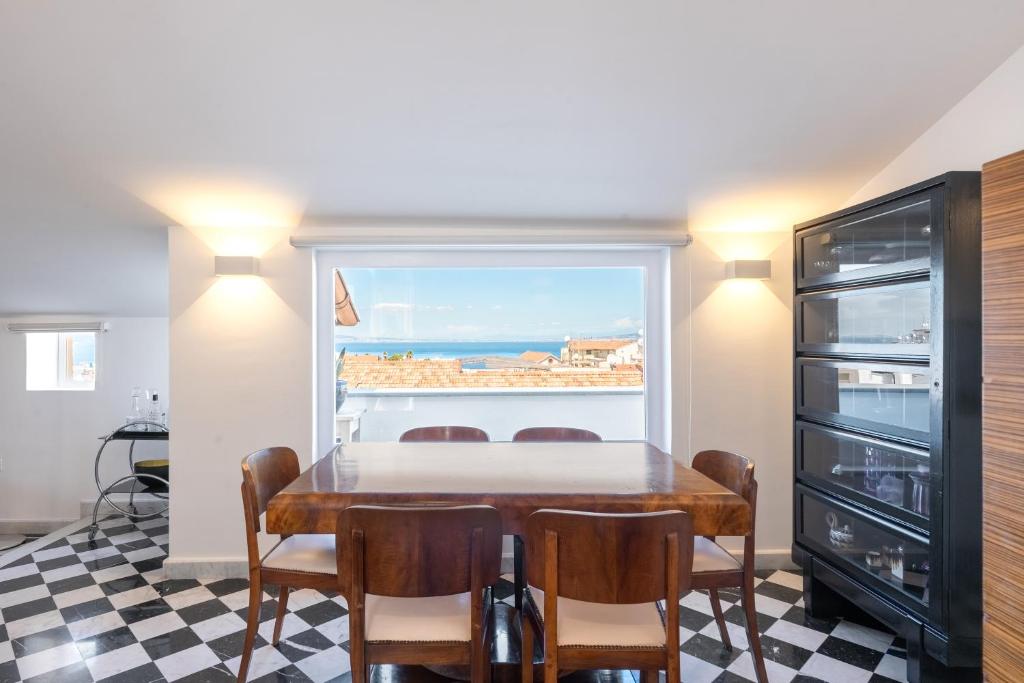 a dining room with a table and chairs and a window at The Roof Sorrento in Sorrento