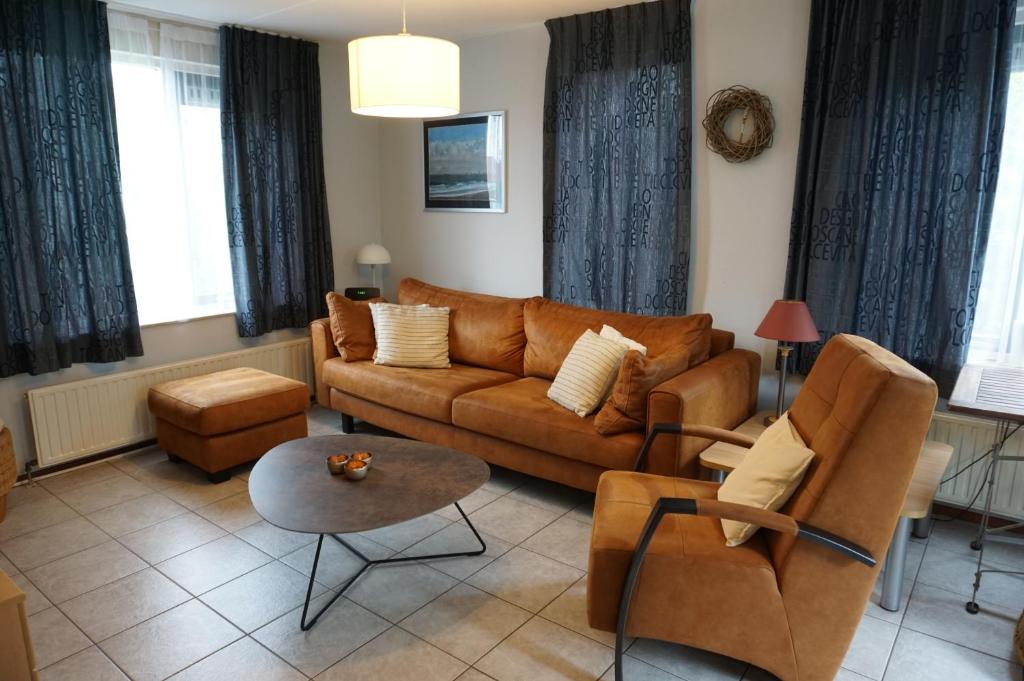 a living room with a brown couch and chairs at Kustverhuur, Park Schoneveld, Stern 233 in Breskens