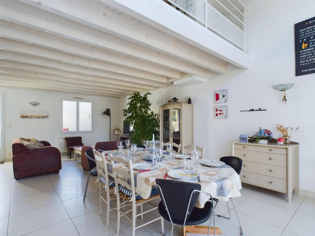 a dining room with a table and chairs at Maison pour 8 avec jardin a 600m de la plage in Le Sablais