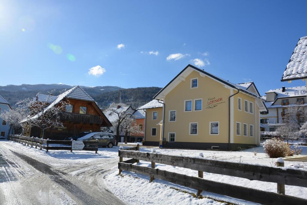 a village in the snow with a fence and a building at Haus Ofner am Kreischberg in Sankt Georgen ob Murau