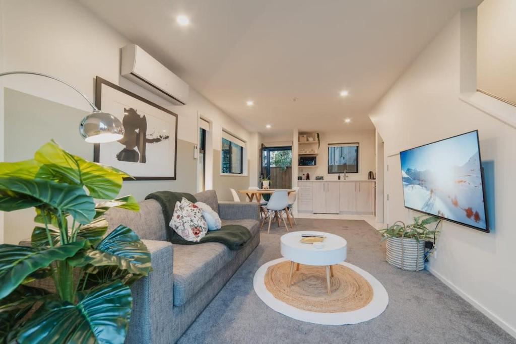 クライストチャーチにあるMisty Meadows Manor - Your Urban Oasisのソファとテーブルのあるリビングルーム