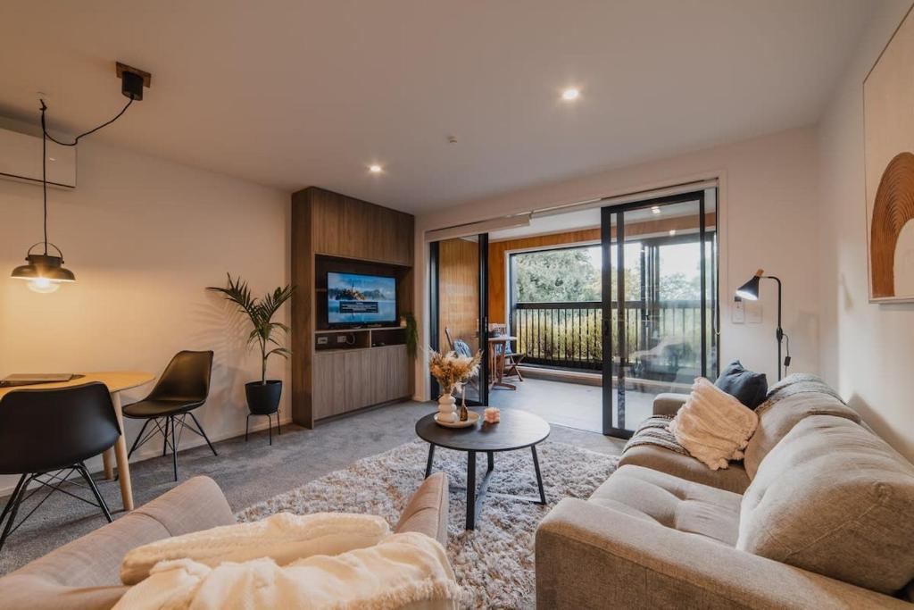 a living room with a couch and a table at The Hagley Park Stunna in Christchurch
