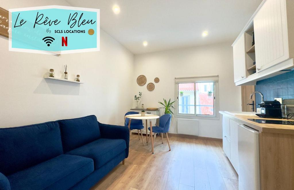 un salon avec un canapé bleu et une cuisine dans l'établissement Rêve Bleu By SCLS Locations, à Cannes