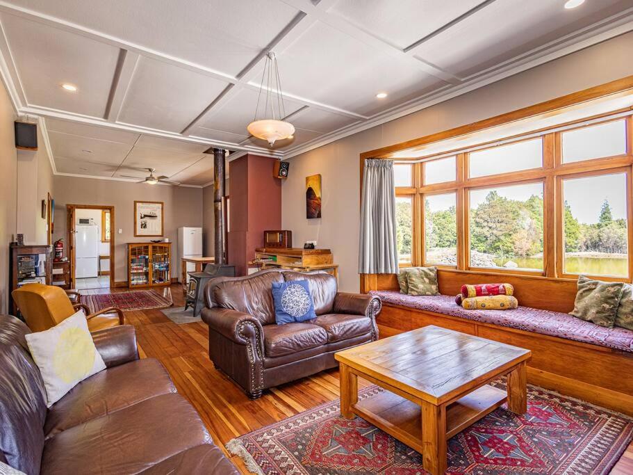 a living room with leather furniture and a table at MJ's Retreat Stunning Ski Season Special for 2024 in Ohakune