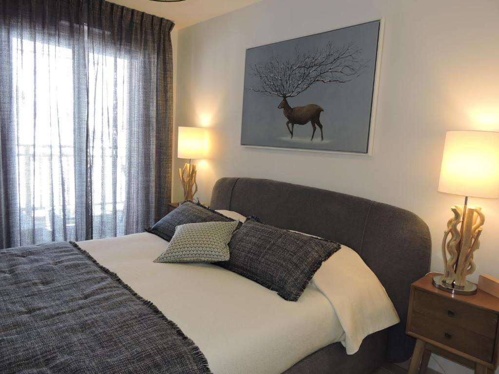 - une chambre dotée d'un lit avec une photo de cerf sur le mur dans l'établissement La détente, vues, espaces le tout dans une décoration superbe, à Auron