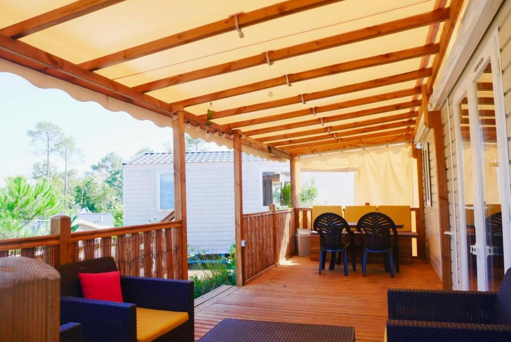 une terrasse en bois avec des chaises et une table dans l'établissement Vue bassin Arcachon mobil-home top 8 personnes by Vayny, à Lège-Cap-Ferret