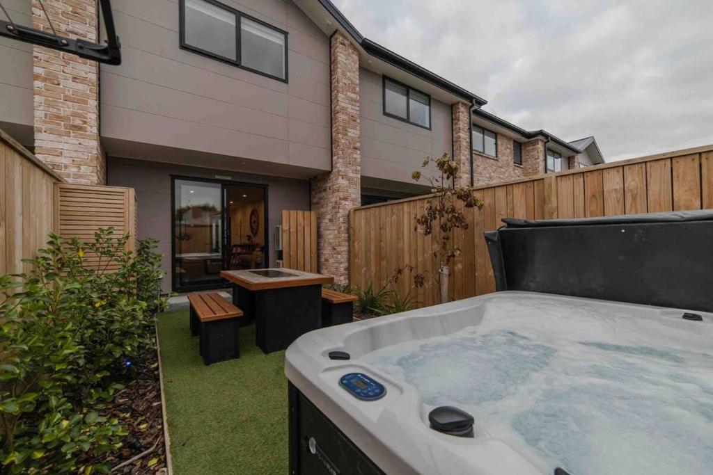 a hot tub in a yard next to a house at Stones Throw From the Stadium & Hot Tub in Christchurch