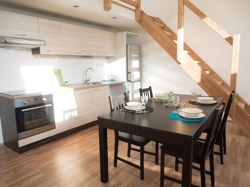 a kitchen and dining room with a black table and chairs at Apartment Brno Reissigova in Brno