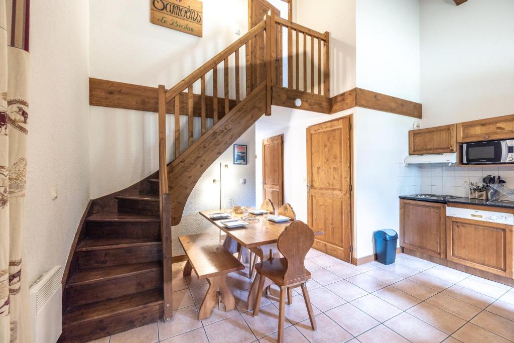 eine Küche und ein Esszimmer mit einer Holztreppe in der Unterkunft Les Fermes de Samoëns in Samoëns