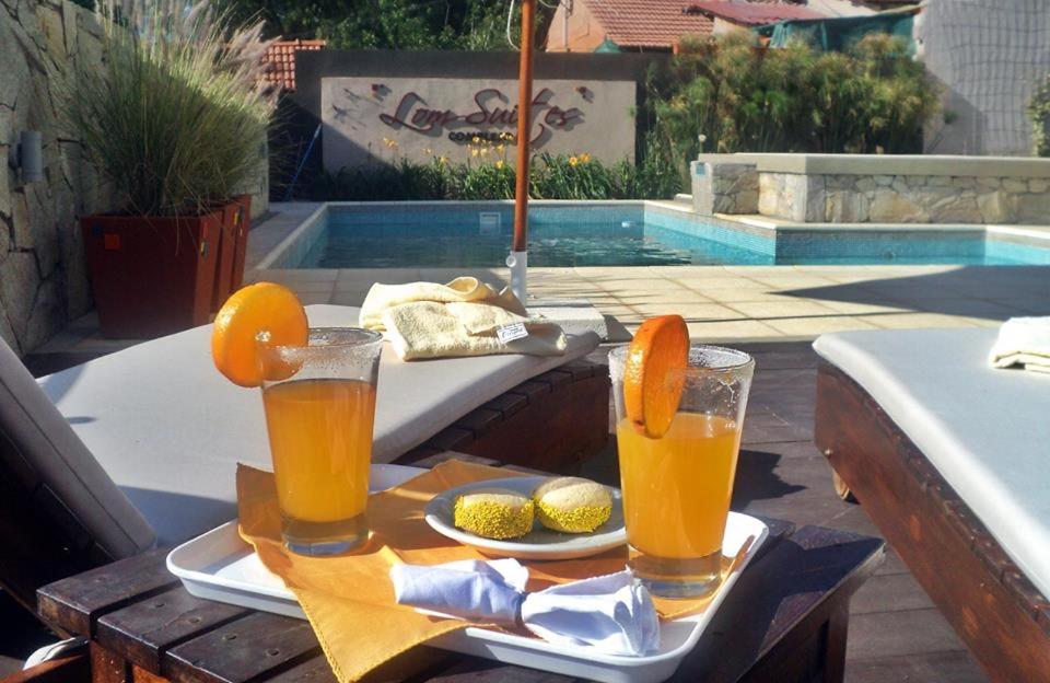 a tray with two glasses of orange juice on a table at Lom Suites in Merlo