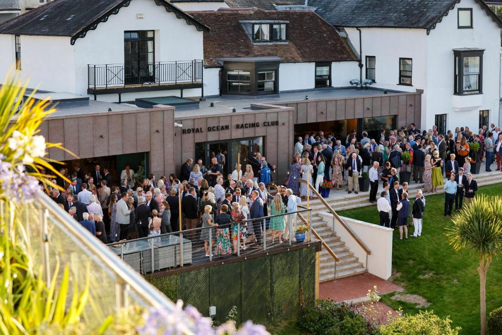a large group of people standing outside of a building at Royal Ocean Racing Club in West Cowes