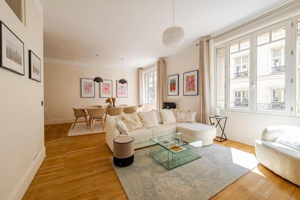 un salon avec un canapé blanc et une table dans l'établissement Exceptionnel près du Louvre & Opéra, à Paris