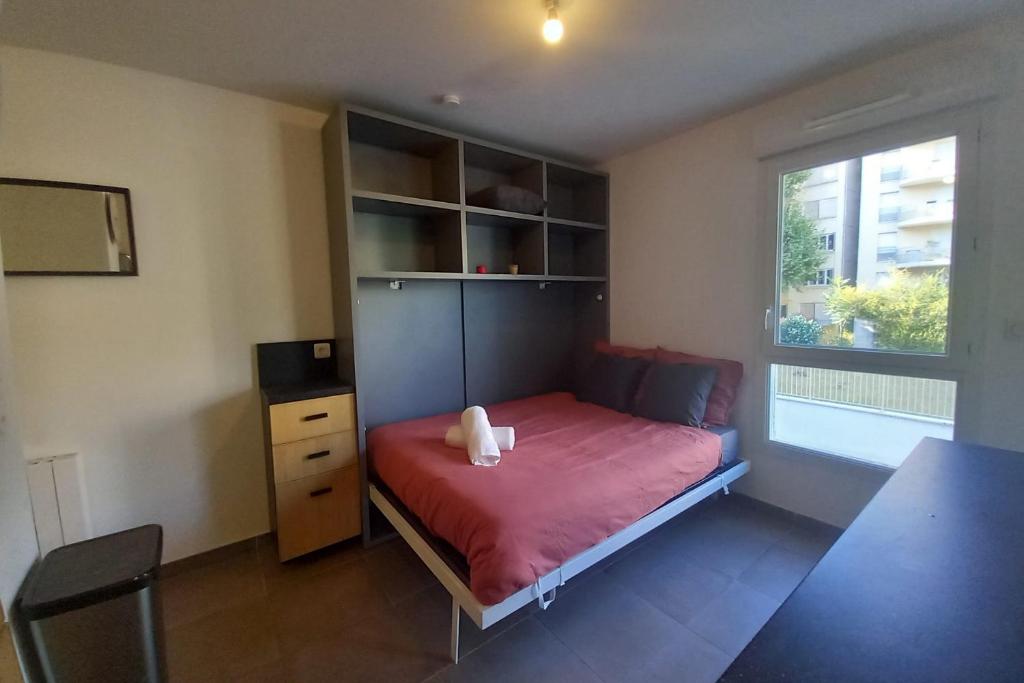 une petite chambre avec un lit et une fenêtre dans l'établissement 69A - Cosy studio ideally located Lyon Gerland, à Lyon