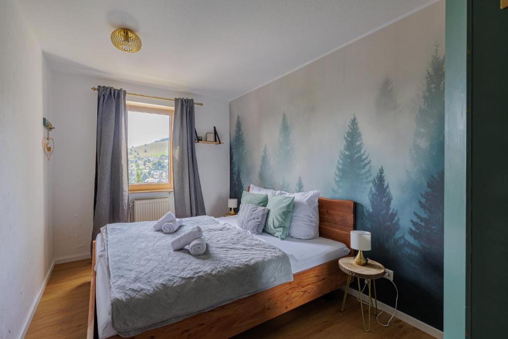 a bedroom with a bed with towels on it at Ideal zum Wandern mit Panoramabalkon Sauna im Haus E-Ladestation in Todtnauberg