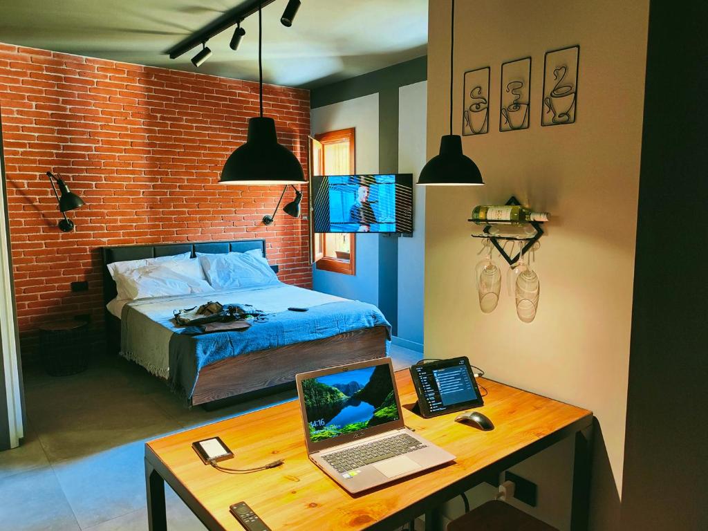 ein Schlafzimmer mit einem Bett und einem Schreibtisch mit einem Laptop in der Unterkunft Stampace Charming in Cagliari