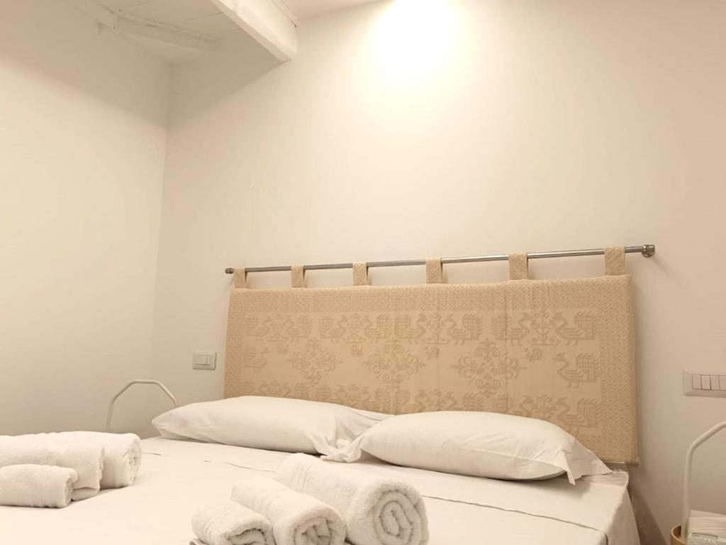 una camera con due letti con lenzuola e asciugamani bianchi di Loft Delitala 1 ad Alghero