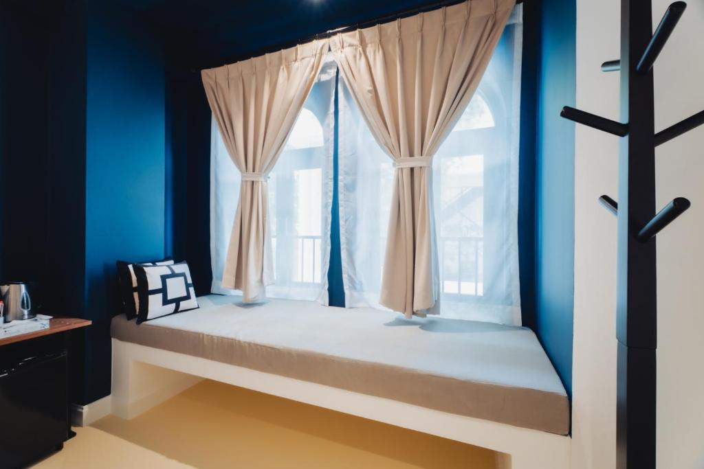 Een bed of bedden in een kamer bij Xinlor House - Phuket Old Town