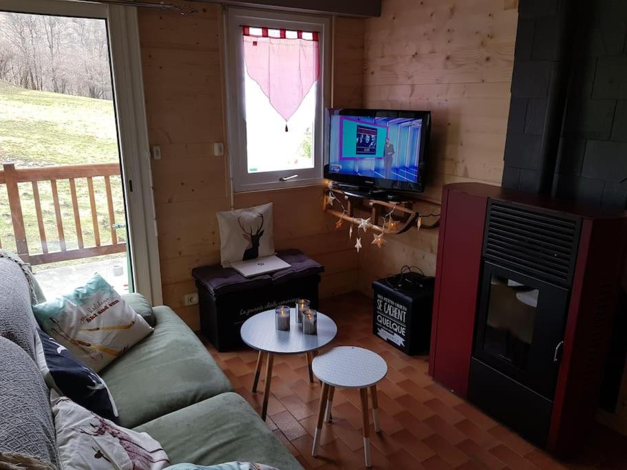 a living room with a couch and a tv and a table at Chalet au cœur de la montagne jacuzzi privé in Sainte-Marie-de-Campan