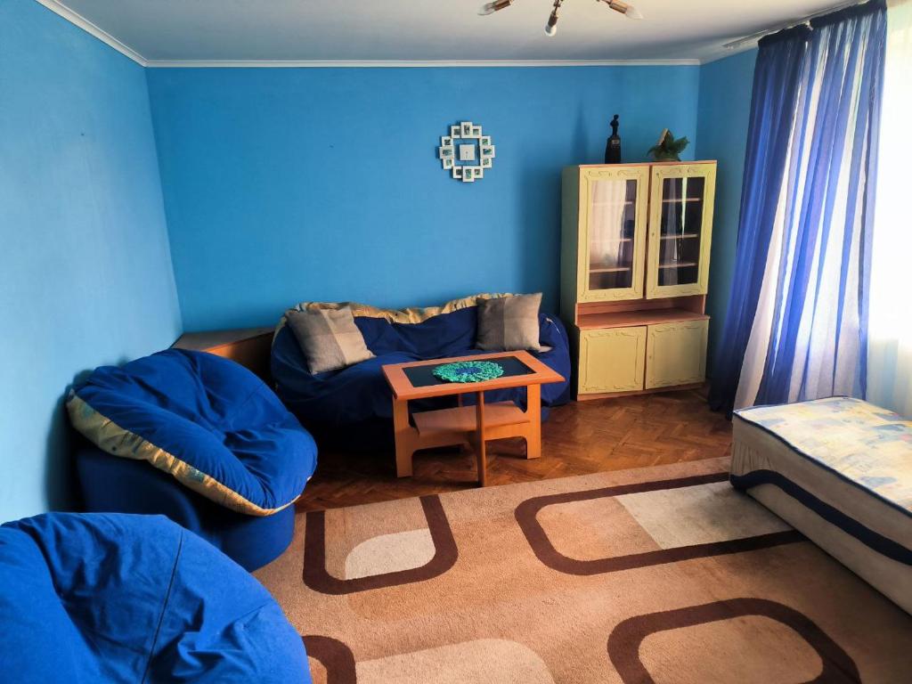 a blue living room with a couch and a table at 3-х комнатная квартира in Okhtyrka