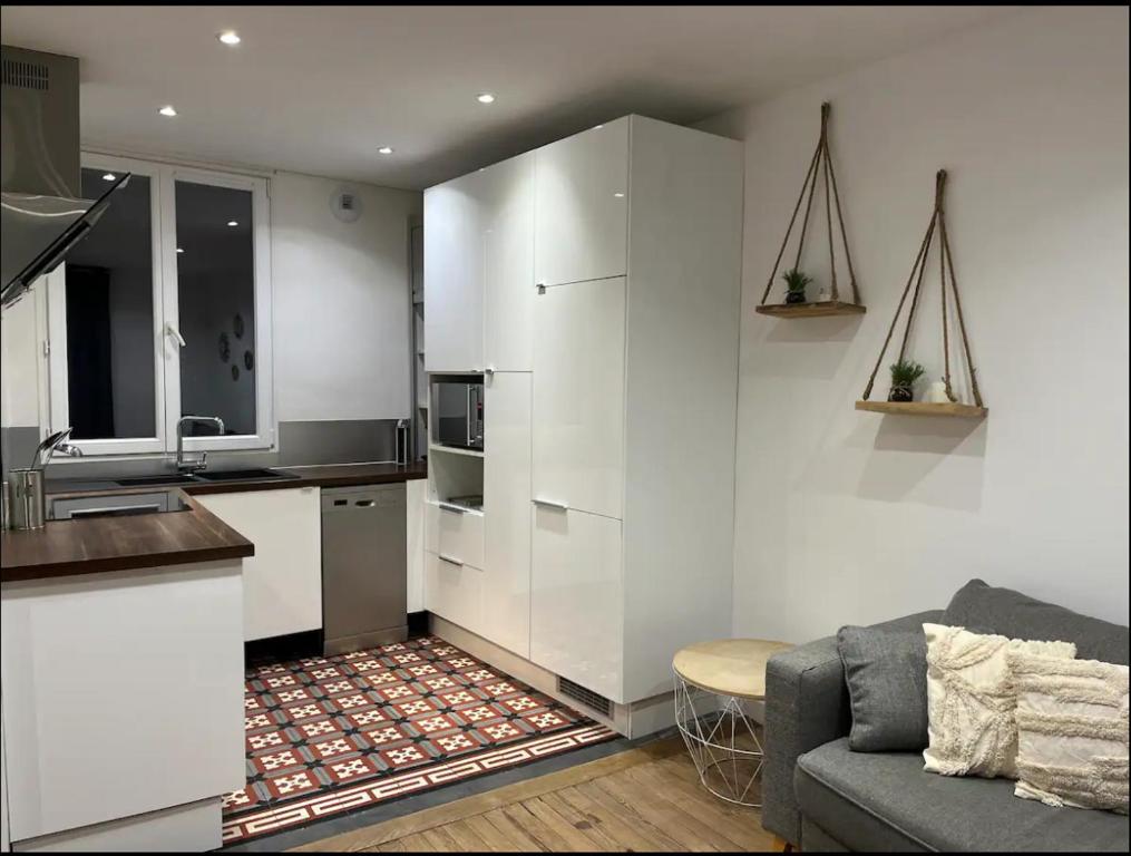 Il comprend une cuisine et un salon avec des murs blancs et un canapé. dans l'établissement Authentique House à côté de Disneyland Paris, à Montévrain