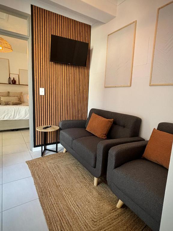 a living room with a couch and a tv at Stylish unit with amazing view in Hentiesbaai