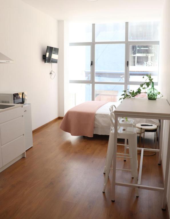 a bedroom with a bed and a desk and a table at Moderno y lujoso Apartamento CASTELAR 2 in Alcazar de San Juan