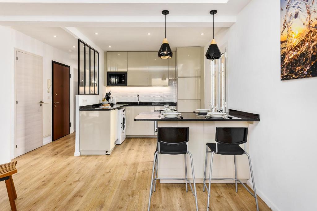 une cuisine avec des armoires blanches et un comptoir avec des tabourets dans l'établissement 