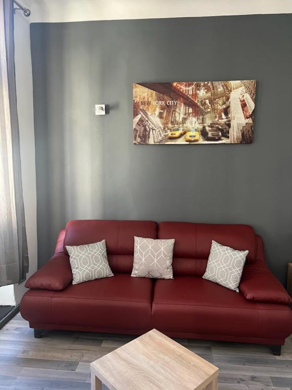 - un canapé rouge dans le salon orné d'une peinture murale dans l'établissement le petit Marseillais, à Marseille