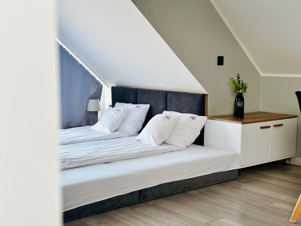 Angled bedroom view showing twin beds with dark headboard and side cabinet topped with vase