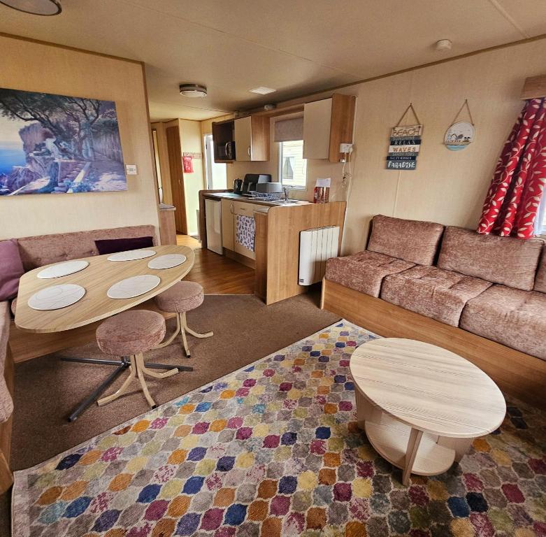 a living room with a couch and a table at 3 Bed Standard caravan Robinhood in Rhyl