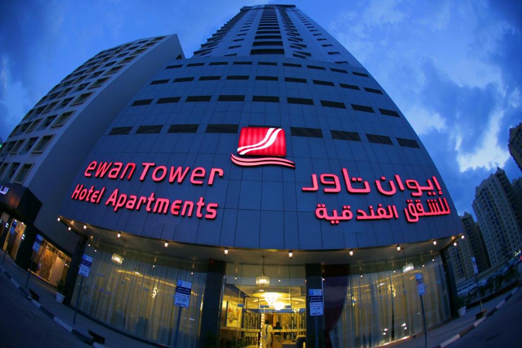 un edificio con un cartel que lee hasta apartamentos de hotel en la torre en Ewan Tower Hotel Apartments, en Ajman