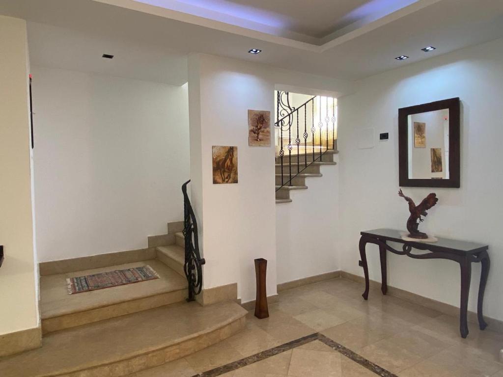 a room with stairs and a table and a stair case at Modern Villa in Madinaty