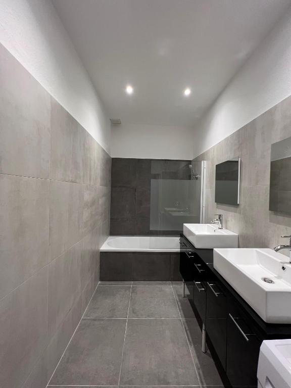 une salle de bain avec deux lavabos et une baignoire dans l'établissement Appartement Deluxe - Jean Jaurès, à Saint-Étienne