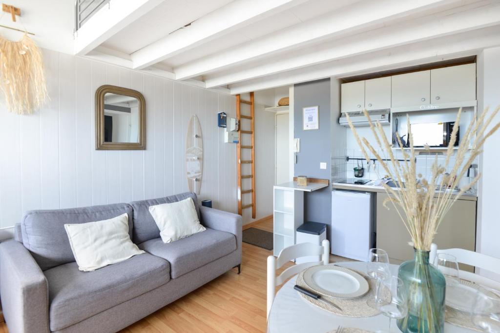 un salon avec un canapé et une table dans l'établissement L’Oasis des Nouveaux Bassins - apt vue port, à Courseulles-sur-Mer