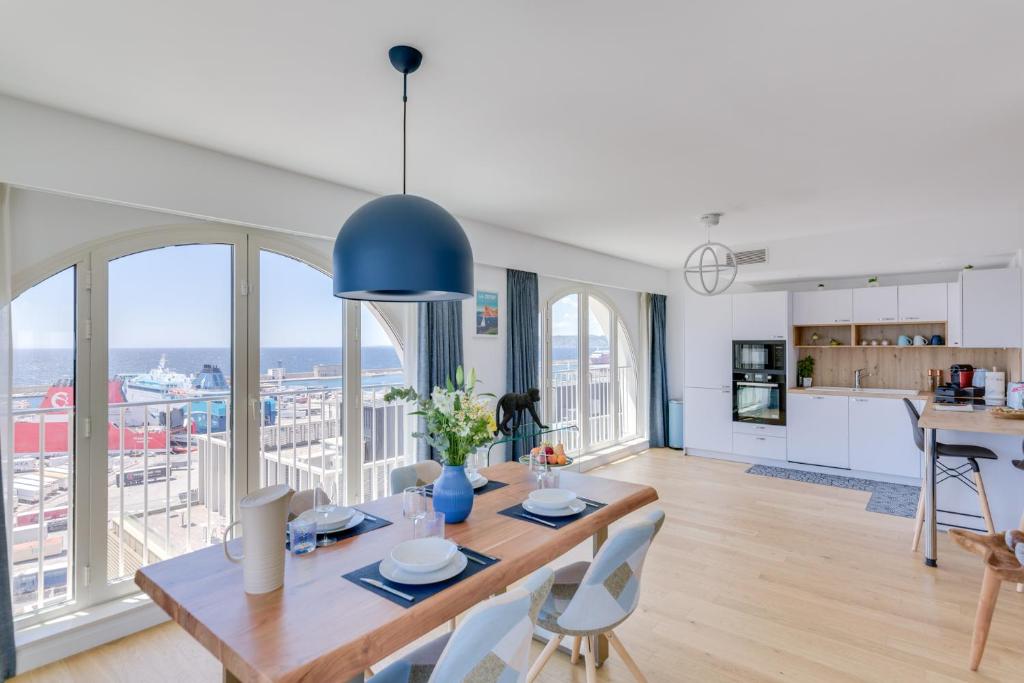 une cuisine et un salon avec une table et des chaises dans l'établissement Luxe, vue mer et parking privé, à Marseille