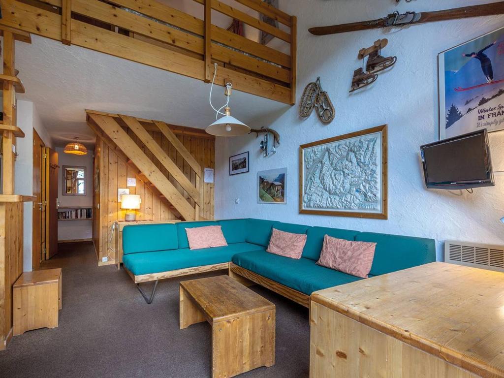 a living room with a blue couch and a tv at Duplex spacieux avec terrasse, garage, et WIFI à Méribel - FR-1-355-7 in Méribel