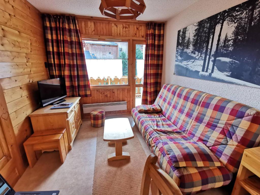 un salon avec un canapé et une télévision dans l'établissement Appartement familial à Méribel, proche des pistes, balcon et casier à skis - FR-1-355-37, à Méribel